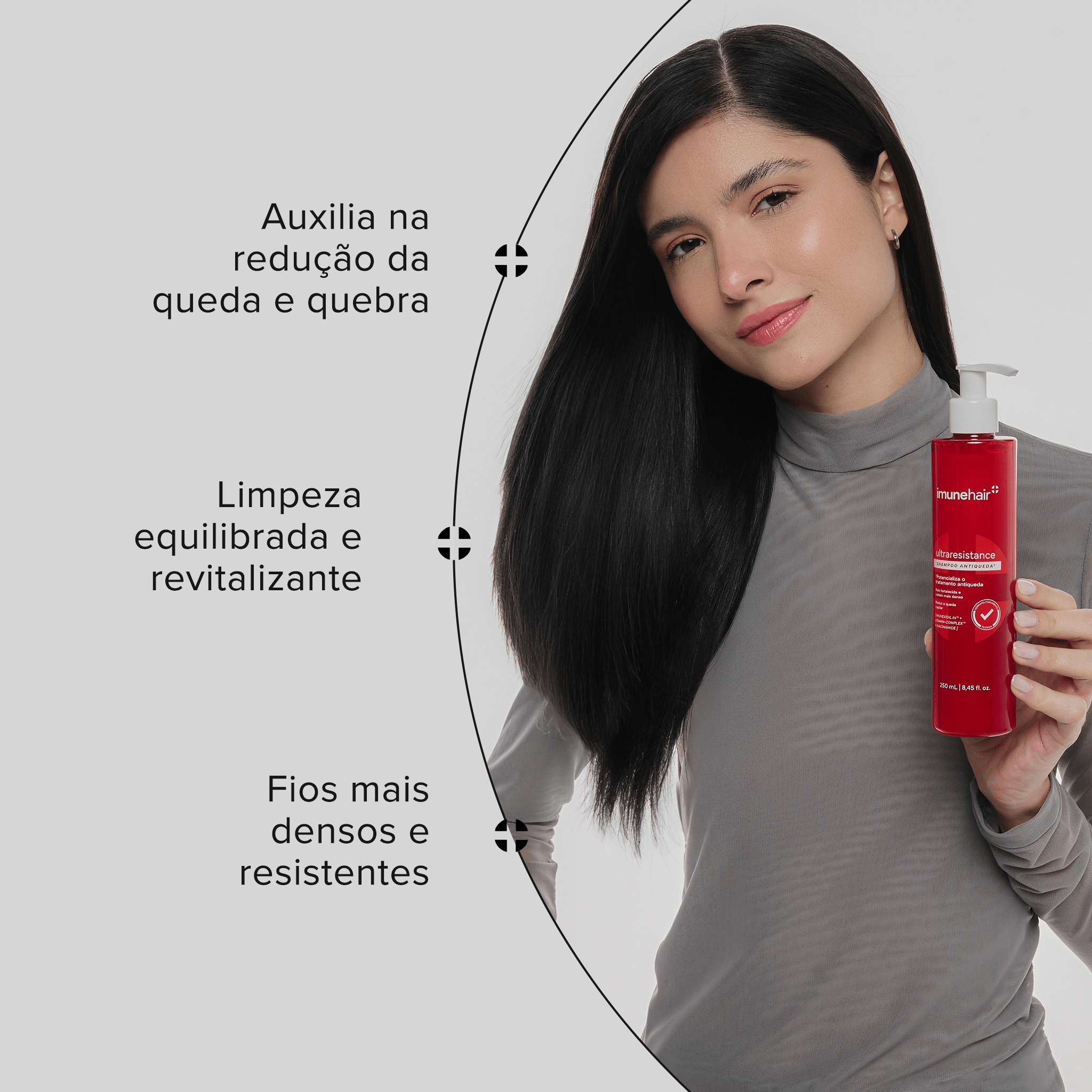 Mulher morena, segurando o shampoo antiqueda que auxilia na redução da queda e quebra. Promove fios mais densos e resistentes, limpa e revitaliza.