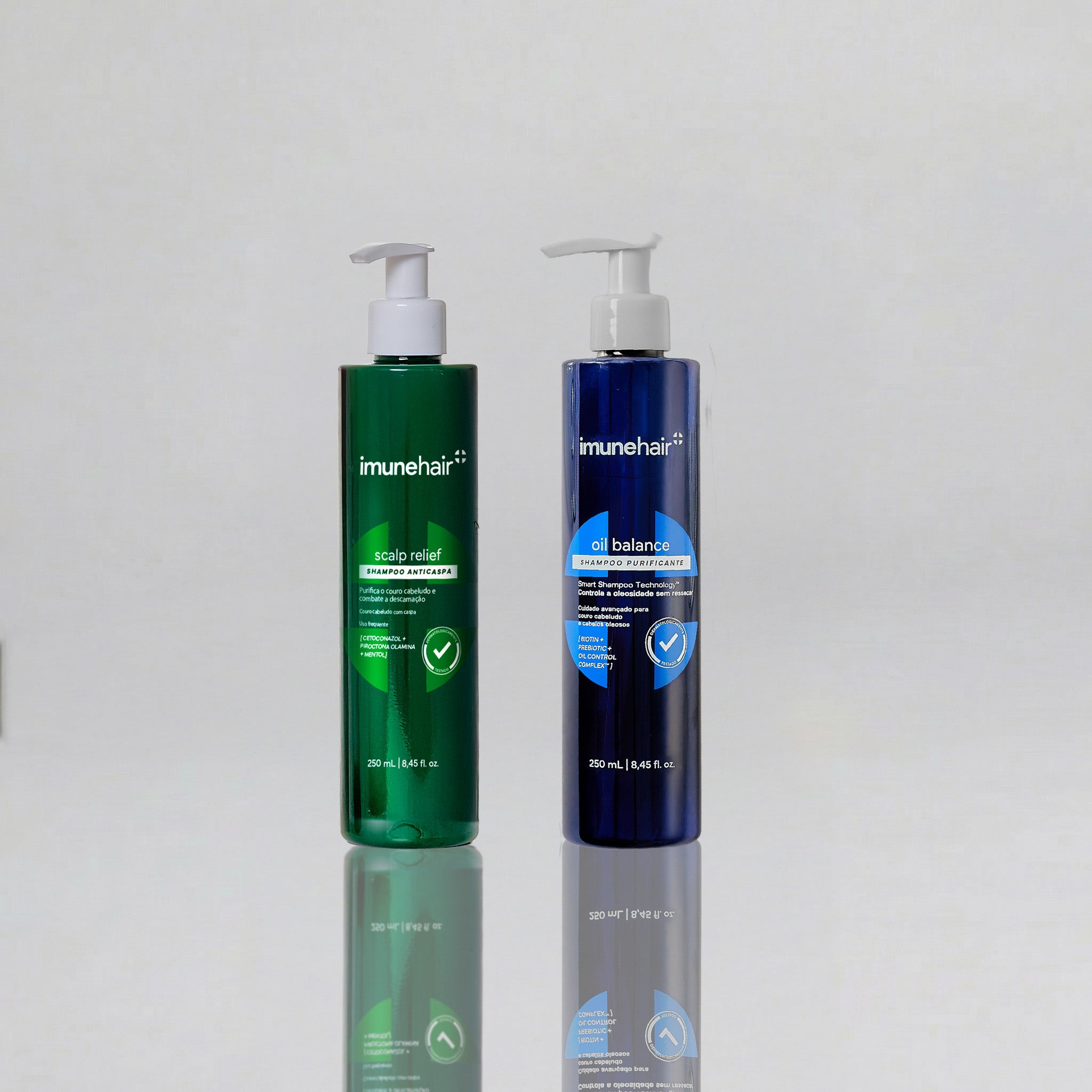 Uma embalagem verde do shampoo anticaspa, com o nome Scalp Relief Shampoo Anticaspa de 250ml. Outra embalagem azul do shampoo antioleosidade, com o nome Oil Balance Shampoo Purificante de 250ml.